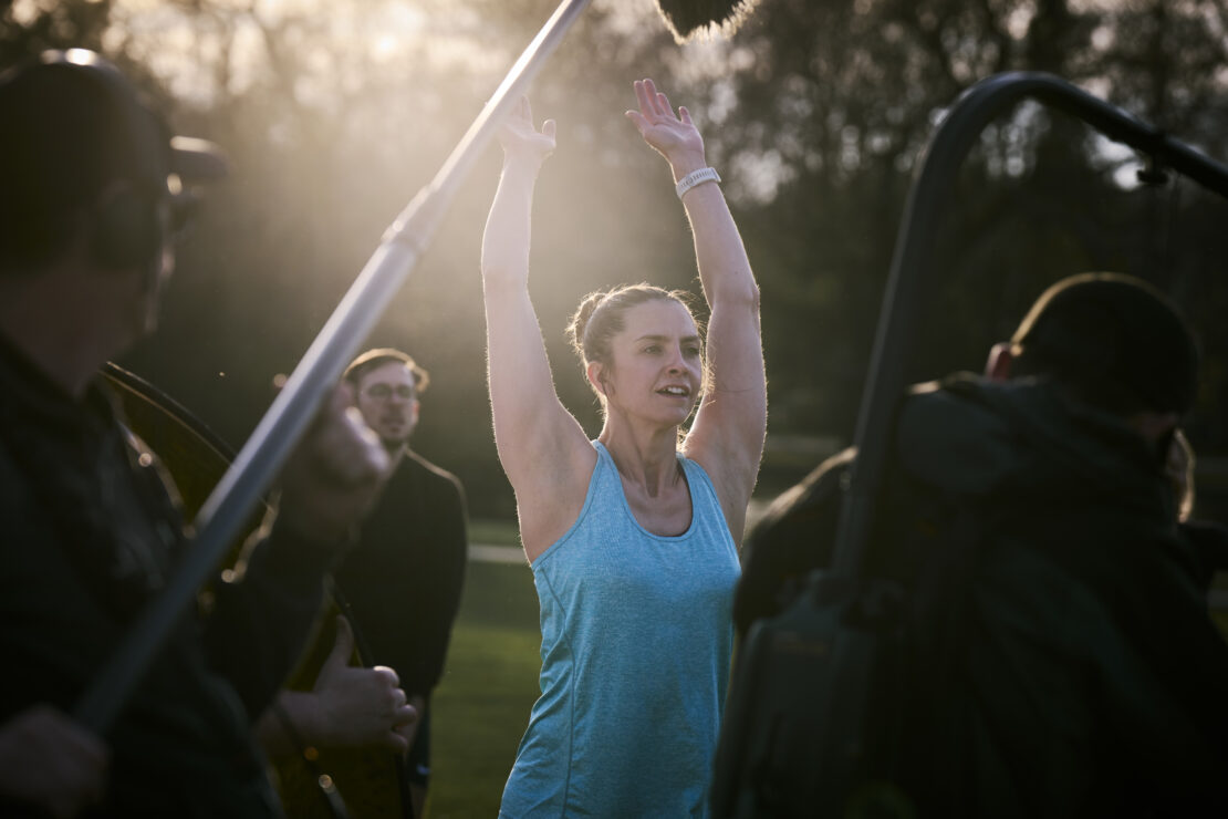 Behind the scenes of 'I'm Tired of This' film - a woman exercising in a park.